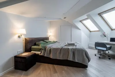 a bedroom with a large bed and a desk at Domillion Amazing 3bdr Penthouse with Terrace MZ28 in Vilnius
