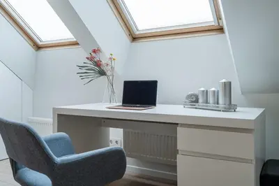 a white desk with a laptop and a chair at Domillion Amazing 3bdr Penthouse with Terrace MZ28 in Vilnius