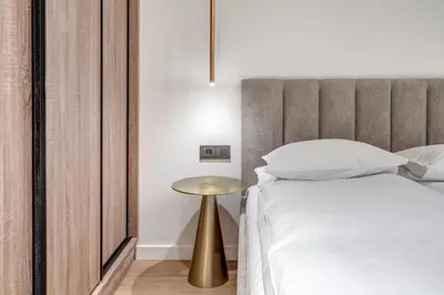 a bedroom with a bed and a gold side table at Domillion 1bdr Modern Old Town Retreat So1a in Vilnius