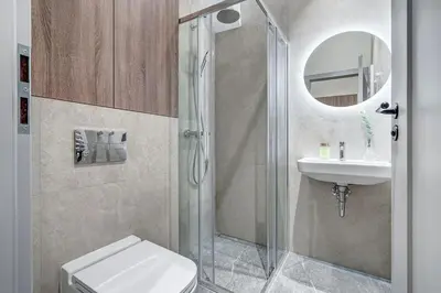 a bathroom with a shower and a toilet and a sink at Domillion 1bdr Modern Old Town Retreat So1a in Vilnius