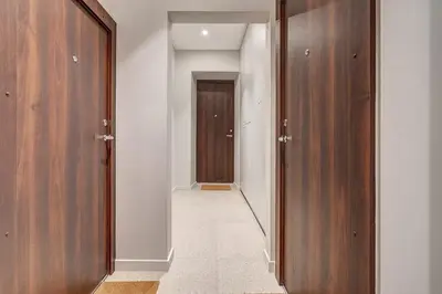 a hallway with two wooden doors and a hallway leading to a door at Domillion 1bdr Modern Old Town Retreat So1a in Vilnius
