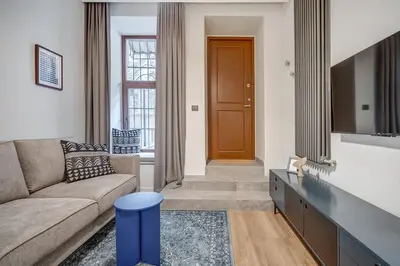 a living room with a couch and a brown door at Domillion 1bdr Modern Old Town Retreat So1a in Vilnius