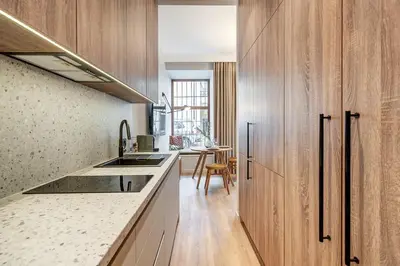 a kitchen with wooden cabinets and a counter top at Domillion Studio Modern Old Town Retreat So1c in Vilnius
