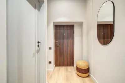 a hallway with a door and a stool and a mirror at Domillion Studio Modern Old Town Retreat So1c in Vilnius
