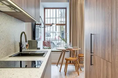 a kitchen with a sink and a table with chairs at Domillion Studio Modern Old Town Retreat So1c in Vilnius