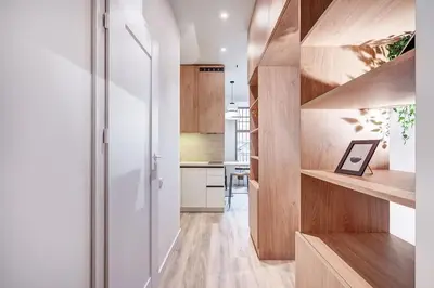 a kitchen with wooden floors and a hallway with wooden shelves at Domillion Studio Modern Old Town Retreat So1b in Vilnius