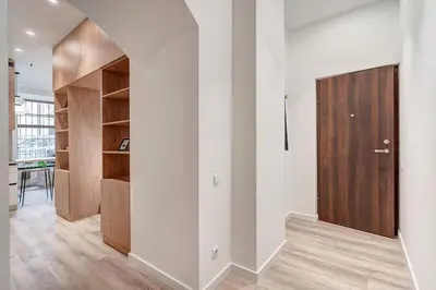 a hallway with white walls and a wooden door at Domillion Studio Modern Old Town Retreat So1b in Vilnius