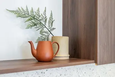 a brown vase sitting on a wooden shelf with a plant at Domillion 2bdr Modern Old Town Retreat So1d in Vilnius