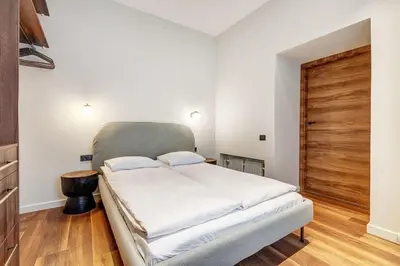 a bedroom with a large bed with a wooden door at Domillion 2bdr Modern Old Town Retreat So1d in Vilnius