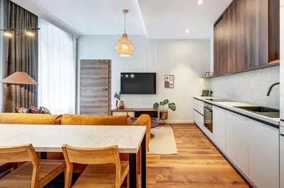 a kitchen and living room with a table and a couch at Domillion 2bdr Modern Old Town Retreat So1d in Vilnius