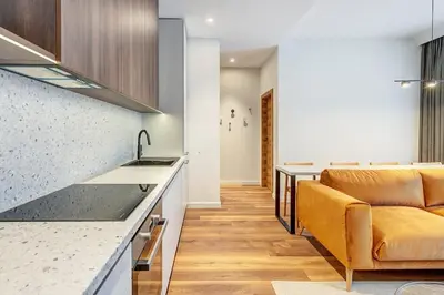 a kitchen and living room with a couch and a counter at Domillion 2bdr Modern Old Town Retreat So1d in Vilnius
