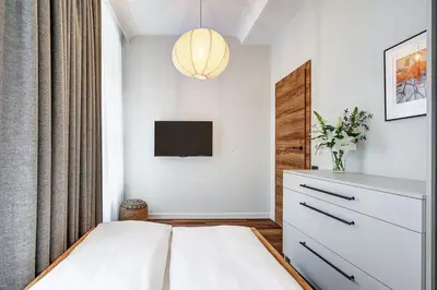 a bedroom with a bed and a tv on a wall at Domillion 5bdr Modern Urban Fourplex So1F in Vilnius