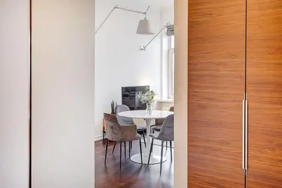a dining room with a table and a wooden door at Domillion 2bdr Bright&Central apt PA227 in Vilnius
