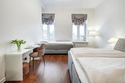 a bedroom with two beds and a desk with a chair at Domillion 2bdr Bright&Central apt PA227 in Vilnius