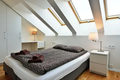a bedroom with a bed in a room with skylights at Domillion Pylimo Penthouse duplex apt 15ppl P36D in Vilnius
