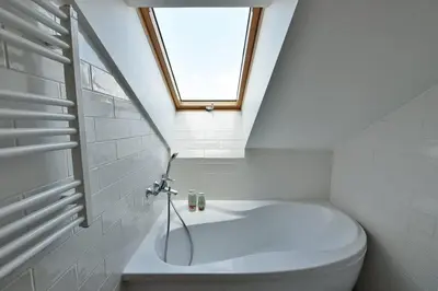 a bathroom with a toilet and a window at Domillion Pylimo Penthouse duplex apt 15ppl P36D in Vilnius