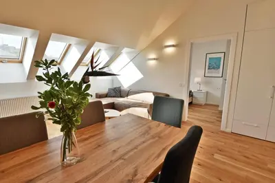 a living room with a table with a vase of flowers at Domillion Pylimo Penthouse duplex apt 15ppl P36D in Vilnius