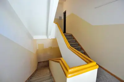 a staircase in a building with a yellow hand rail at Domillion Penthouse Duplex w Terrace 18 ppl P36T in Vilnius