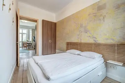 a bedroom with a white bed and a painting on the wall at Domillion Penthouse Duplex w Terrace 18 ppl P36T in Vilnius