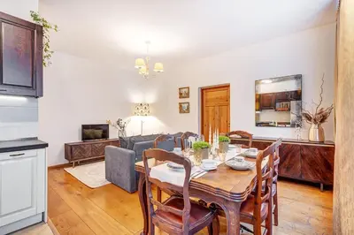 a dining room and living room with a table and chairs at Domillion Cozy 2bdr apt on Stikliu str S43 in Vilnius