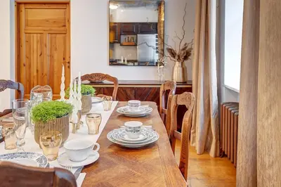 a wooden table with plates and cups on it at Domillion Cozy 2bdr apt on Stikliu str S43 in Vilnius