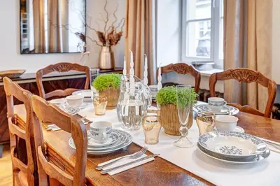 a wooden table with plates and glasses on it at Domillion Cozy 2bdr apt on Stikliu str S43 in Vilnius