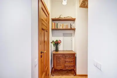 a hallway with a vase of flowers on a wooden cabinet at Domillion Cozy 2bdr apt on Stikliu str S43 in Vilnius