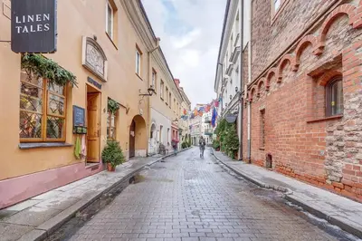 an empty street in an alley between buildings at Domillion Cozy 2bdr apt on Stikliu str S43 in Vilnius