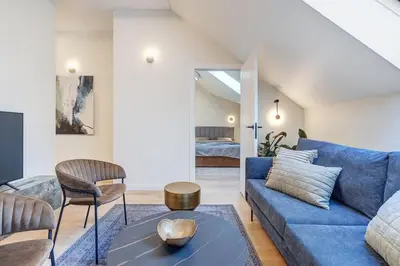 a living room with a blue couch and a bed at Domillion oldtown new 5bdr 3bath apt P492a in Vilnius
