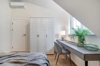 a bedroom with a bed and a desk and a window at Domillion oldtown new 5bdr 3bath apt P492a in Vilnius