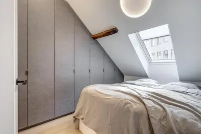 a attic bedroom with a bed and a window at Domillion oldtown new 5bdr 3bath apt P492a in Vilnius
