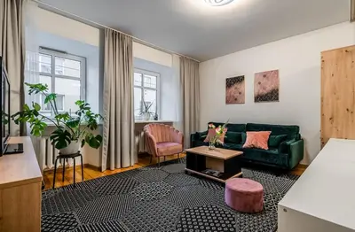 a living room with a green couch and a table at Domillion 1bdr Traku str apt&free parking Tr135 in Vilnius