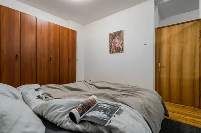 a bed with a book on it in a bedroom at Domillion 1bdr Traku str apt&free parking Tr135 in Vilnius
