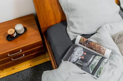 a bedroom with a bed with a nightstand with a book on it at Domillion 1bdr Traku str apt&free parking Tr135 in Vilnius