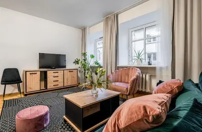 a living room with a green couch and a tv at Domillion 1bdr Traku str apt&free parking Tr135 in Vilnius