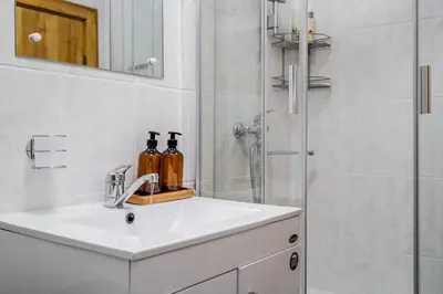 a white bathroom with a sink and a shower at Domillion 1bdr Traku str apt&free parking Tr135 in Vilnius