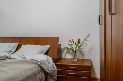 a bedroom with a bed and a vase with flowers on a night stand at Domillion 1bdr Traku str apt&free parking Tr135 in Vilnius
