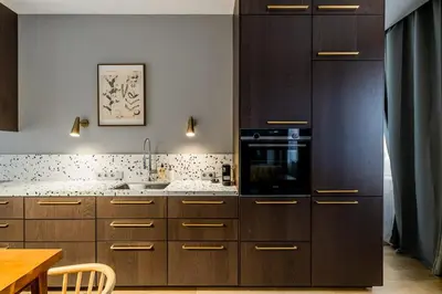 a kitchen with wooden cabinets and a stove top oven at Domillion 1bdr brand-new Uzupis apt w free parking in Vilnius