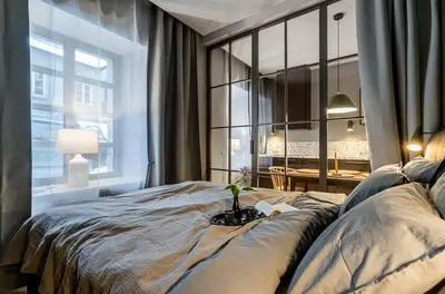 a bedroom with a large bed and a large window at Domillion 1bdr brand-new Uzupis apt w free parking in Vilnius