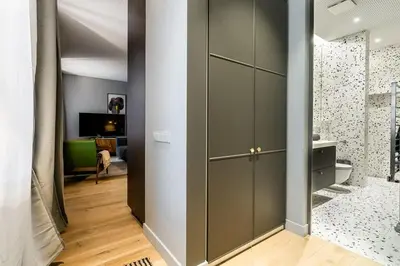 a room with gray cabinets and a living room at Domillion 1bdr brand-new Uzupis apt w free parking in Vilnius