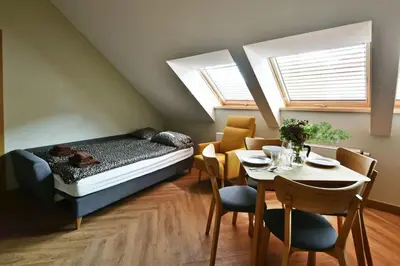 a bedroom with a bed and a table and chairs at Domillion New Modern Old town apt 14 ppl U2C2 in Vilnius