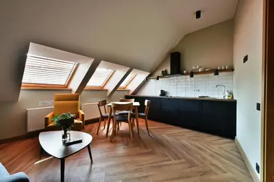 a kitchen and a living room with a table and chairs at Domillion New Modern Old town apt 14 ppl U2C2 in Vilnius