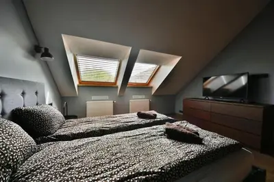 a bedroom with a large bed and a flat screen tv at Domillion New Modern Old town apt 14 ppl U2C2 in Vilnius