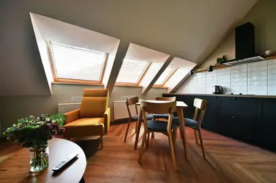 a kitchen with a table and chairs in a room at Domillion New Modern Old town apt 14 ppl U2C2 in Vilnius