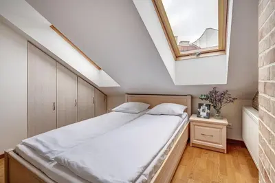 a bedroom with a bed with a skylight at Domillion New 2bdr Old Town Amber apt Z1B5 in Vilnius