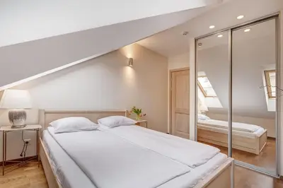 a bedroom with a large white bed and a mirror at Domillion New 2bdr Old Town Amber apt Z1B5 in Vilnius