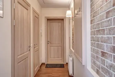 a hallway with a door and a brick wall at Domillion New 2bdr Old Town Amber apt Z1B5 in Vilnius