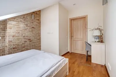 a bedroom with a bed and a brick wall at Domillion New 2bdr Old Town Amber apt Z1B5 in Vilnius