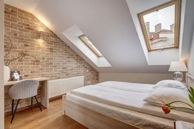 a bedroom with a bed and a brick wall at Domillion New 2bdr Old Town Amber apt Z1B5 in Vilnius