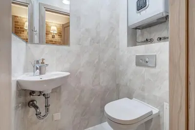 a white bathroom with a toilet and a sink at Domillion New 2bdr Old Town Amber apt Z1B5 in Vilnius